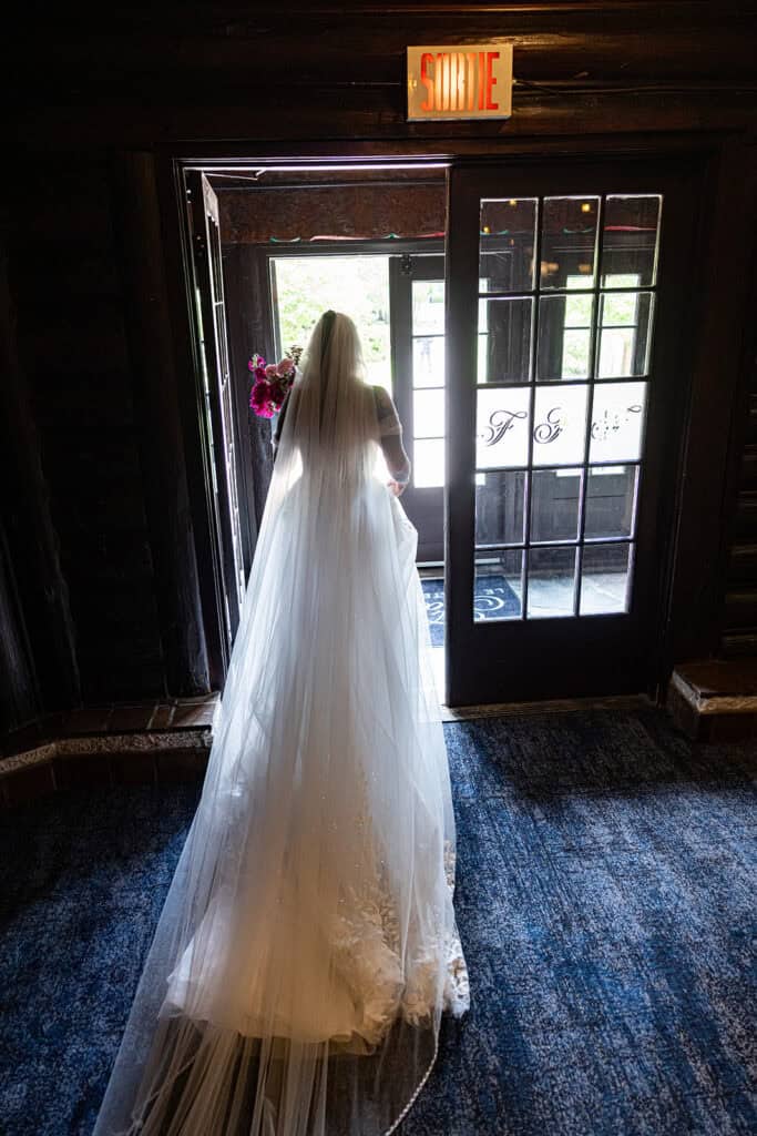 A bride is walking out the Chateau Montebello, QC before the wedding ceremony